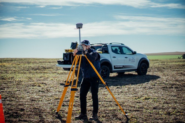 GEOLAND professional conducting a GNSS survey beside a vehicle